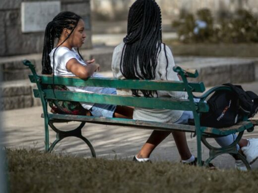 black women on park bench talking